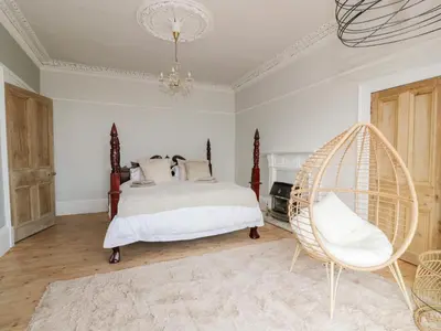 a bedroom with a bed and a chair at Mars Hill Lower in Dunoon