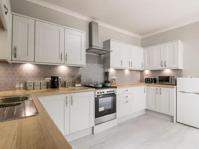 a kitchen with white cabinets and white appliances at Mars Hill Lower in Dunoon