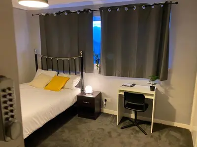a bedroom with a bed and a desk and a window at Culbin Lodge in Glasgow