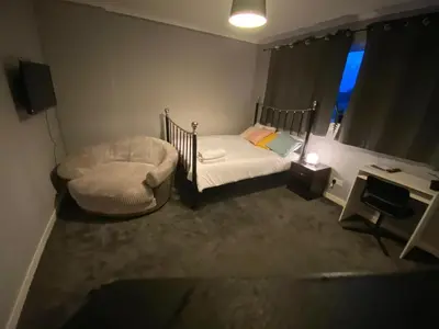 a small bedroom with a bed and a desk at Culbin Lodge in Glasgow
