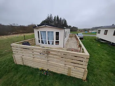 a tiny house on a deck in a yard at Just Resort No29 in Balminnoch