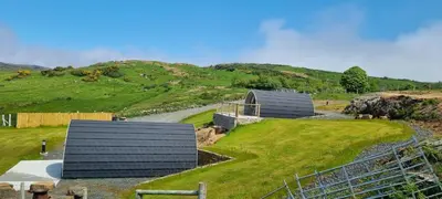 two roofs of two buildings on a grassy hill at Fairhead Glamping Pods in Ballycastle