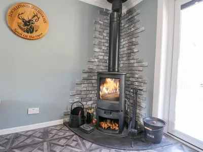 a fireplace in a room with a stone wall at Ben View in Arrochar