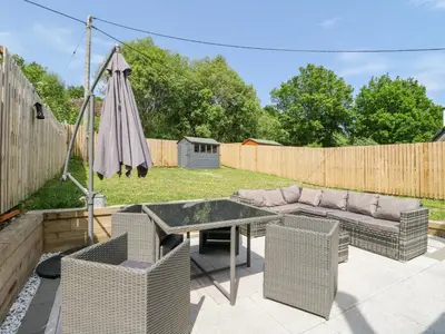 a patio with a table and a couch and an umbrella at Ben View in Arrochar