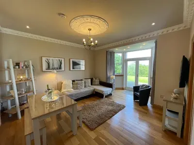 a living room with a couch and a table at Lomond View in Luss