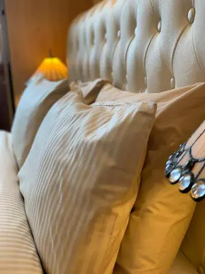 a white bed with a pillow and a lamp at Lomond View in Luss