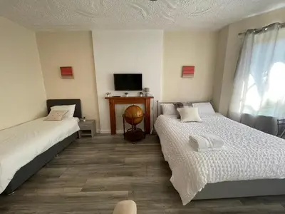 a room with two beds and a tv in it at Earls Lodge in Whiteinch
