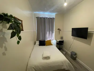 a small bedroom with a bed and a television at Earls Lodge in Whiteinch