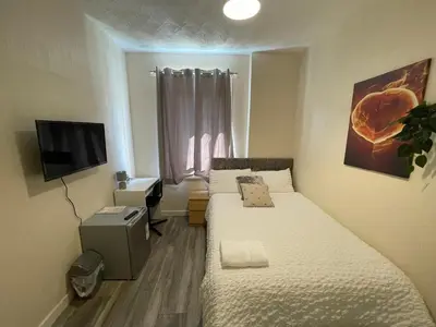 a small bedroom with two beds and a television at Earls Lodge in Whiteinch