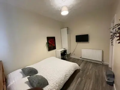 a bedroom with a bed and a flat screen tv at Earls Lodge in Whiteinch
