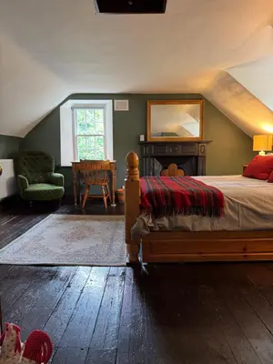 a bedroom with a bed and a chair and a table at East Cottage at Powis House Estate in Stirling