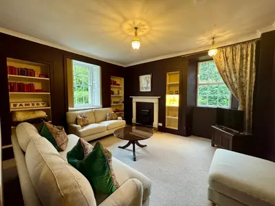 a living room with a couch and a table at Mid Cottage at Powis House Estate in Stirling