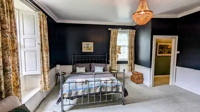 a bedroom with a bed and a black wall at Mid Cottage at Powis House Estate in Stirling