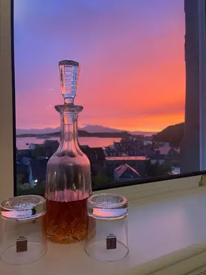 a bottle of honey sitting on a window sill at Kenavara House in Oban