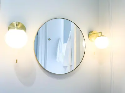 a mirror hanging on a wall with two lights at Kenavara House in Oban