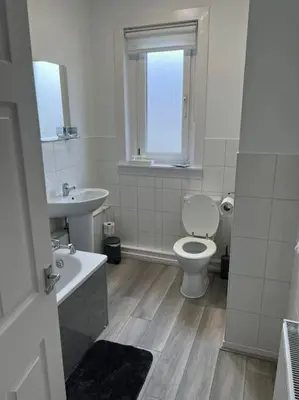 a white bathroom with a toilet and a sink at Cosy Cottage Apartment in Helensburgh