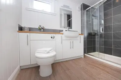 a bathroom with a toilet and a sink and a shower at Lomond View in Langbank