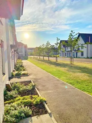 an empty street with houses and trees in a neighborhood at 3 bed house with parking near airport in Edinburgh