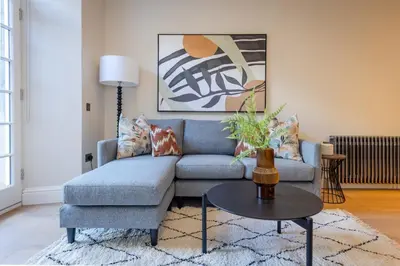 a living room with a blue couch and a table at Dragon Suites Luxury Serviced Apartments at Walker Street in Edinburgh