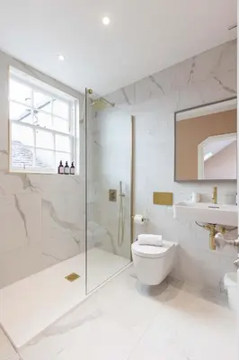 a bathroom with a shower and a toilet and a sink at Dragon Suites Luxury Serviced Apartments at Walker Street in Edinburgh