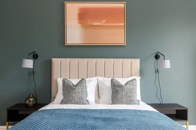 a bedroom with a bed with blue walls and two lamps at Dragon Suites Luxury Serviced Apartments at Walker Street in Edinburgh